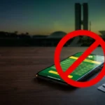 Smartphone showing a crossed-out betting app in front of Brazil's Congress building, illustrating the Brazil betting ban